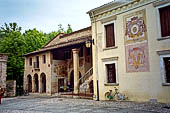 Sesto al Reghena (Pn). Abbazia di Santa Maria in Silvis. Il semplice portale d'ingresso con a destra parte del palazzo del comune già residenza degli abati sulla cui facciata si conservano gli stemmi affrescati di cinque abati commendatari. 